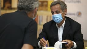 Nicolas Sarkozy en train de signer son livre "Le temps des Tempêtes" en juillet 2020.