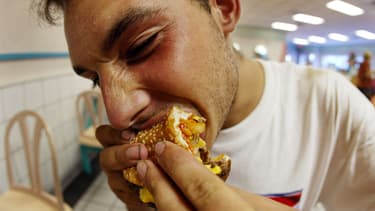 Un homme mangeant un hamburger dans un McDonalds de Miami, en 2002.