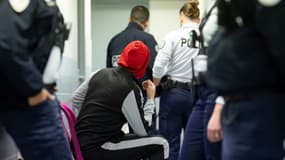 Un migrant attend, au milieu de policiers, devant l'infirmerie du centre de rétention administrative de Vincennes, à l'est de Paris, le 2 novembre 2023
