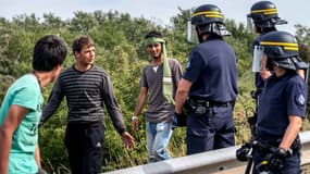 Des policiers interpellent des migrants près du port de Calais, le 5 août 2015.