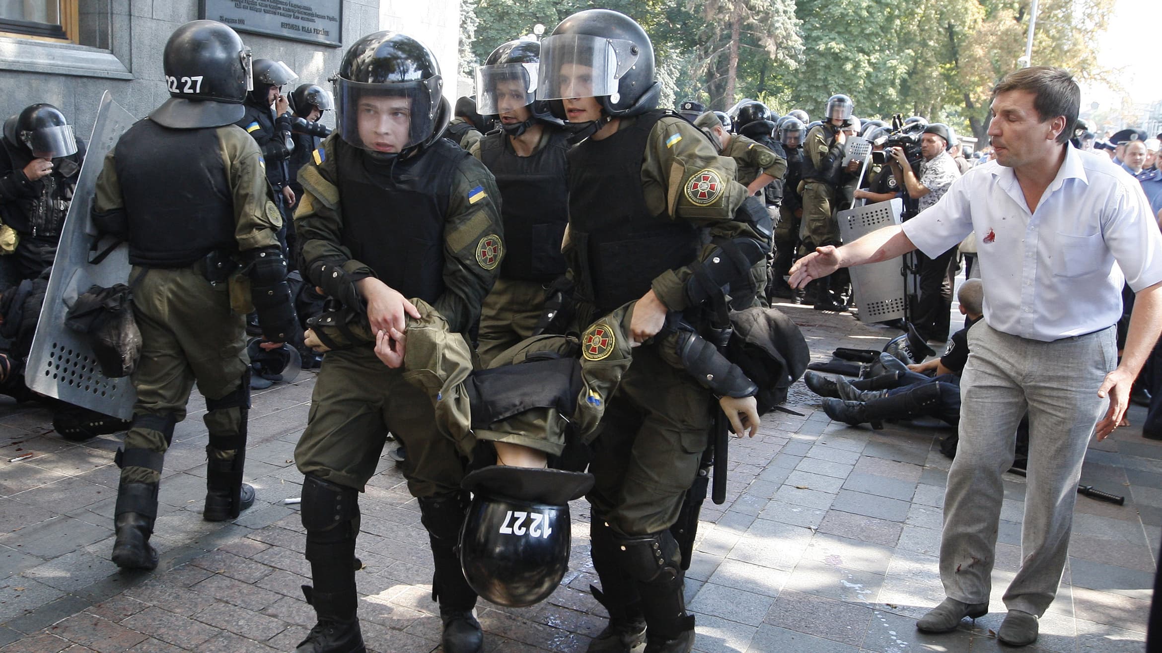 Des membres des forces de l'ordres portent l'un de leurs confrères blessés, le 31 août, à Kiev. Des membres des forces de l'ordres portent l'un de leurs confrères blessés, le 31 août, à Kiev.