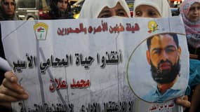 Une Palestinienne tient une affiche représentant Mohammed Allan