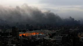 Colonne de fumée au-dessus du Caire. Le quartier général du Parti national démocrate (PND, au pouvoir) était en feu vendredi en début de soirée au Caire peu après l'entrée en vigueur du couvre-feu. /Photo prise le 28 janvier 2011/REUTERS/Yannis Behrakis