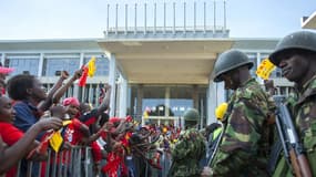 Des partisans d'Uhuru Kenyatta surveillés par l'armée devant le bâtiment où il a donné son discours de victoire, samedi à Nairobi.