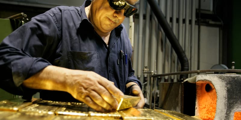 Un employé tient un lingot d'or de 12,5 kg le 6 avril 2009 dans une usine de l'affineur et fabricant de lingots d'or Argor-Heraeus SA à Mendrisio, dans le sud de la Suisse. 