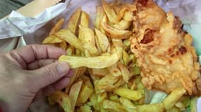 Un client s'attaque à une portion de "fish and chips" servie chez Leo Burdock Fish and Chip à Dublin, le 2 décembre 2020 (photo d'illustration)
