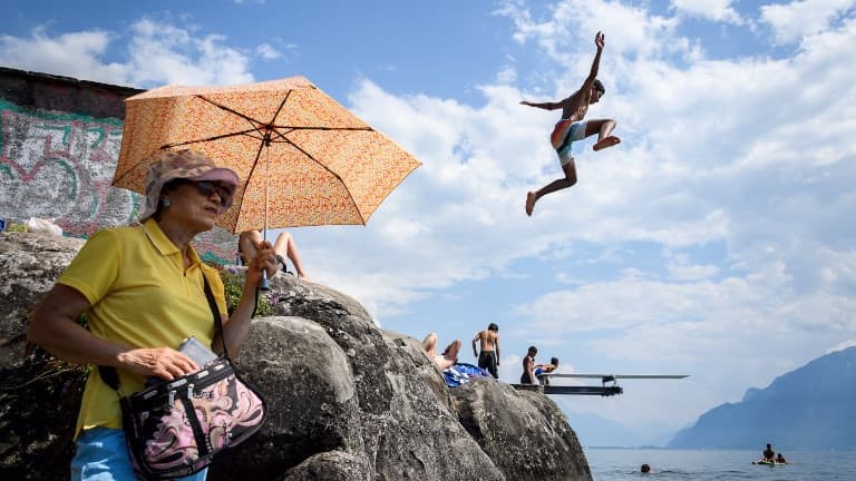Un garçon en train de plonger dans le lac de Genève en Suisse, tandis qu'une femme se protège du soleil à laide d'une ombrelle le 31 juillet dernier. Un garçon en train de plonger dans le lac de Genève en Suisse, tandis qu'une femme se protège du soleil à laide d'une ombrelle le 31 juillet dernier.
