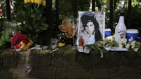 Fleurs et objets déposés devant le domicile d'Amy Winehouse après sa mort, en juillet. La fondation créée après la mort de la chanteuse britannique va financer une bourse à l'école de chant de Londres où son talent a été découvert. /Photo prise le 24 juil