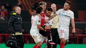 Lisandro Martinez évacué du terrain par Gonzalo Montiel et Marcos Acuna lors de Manchester United-Séville FC, le 13 avril 2023