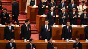 Le président chinois Xi Jinping (c) et le Premier ministre Li Keqiang (d, 2è rang), lors d'un vote sur le changement de la Constitution à l'Assemblée nationale populaire à Pekin, le 11 mars 2018