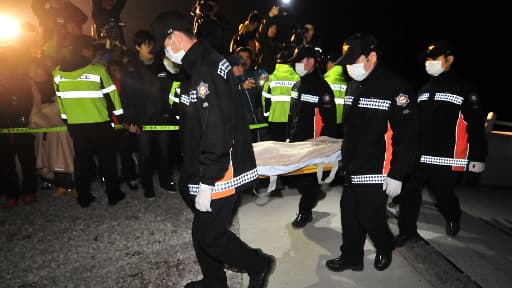 Des sauveteurs transportent un corps retrouvé dans le ferry, samedi.