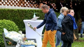 Des employés du CHU de Reims déposent des fleurs devant l'hôpital à Reims, le 23 mai 2023, en hommage à Carène Mezino, décédée à la suite d'une agression au couteau la veille.