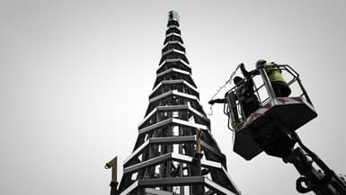 Des ouvriers participent à la construction d'un arbre de Noël de 11 mètres de haut entièrement en acier (recyclable) et en verre (recyclé)  devant la cathédrale Saint-André à Bordeaux, dans le sud-ouest de la France, le 7 décembre 2021.