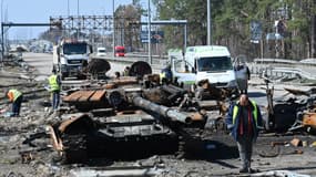 Des Ukrainiens s'affairent pour nettoyer les débris d'un tank sur une route menant à Kiev, jeudi 7 avril 2022
