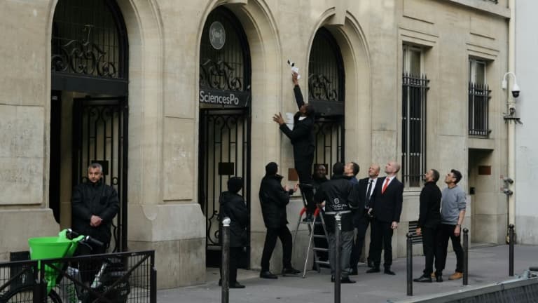 Un agent de sécurité retire une affiche de l'entrée de Sciences Po Paris, après que des étudiants ont pénétré à l'intérieur pour un rassemblement propalestinien, le 7 mai 2024 à Paris