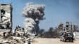 Des personnes regardent des volutes de fumée après une frappe israélienne à Jabalia, dans le nord de la bande de Gaza, le 25 mai 2025.