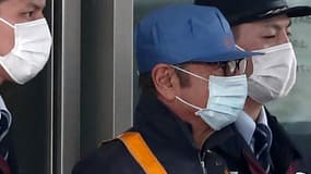 À  sa sortie de prison, Carlos Ghosn, qui portait une casquette et un masque facial, était escorté par des policiers japonais.
