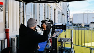 Un homme règle sa caméra pendant le tournage du film THE NEW WORKERS LEAVING THE FACTORY", à l'occasion du 130e anniversaire de la naissance du cinéma, à l'Institut Lumière de Lyon, en France, le 19 mars 2025.
