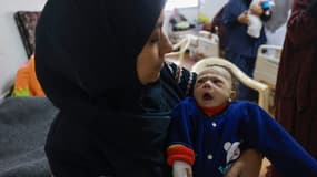 Une femme porte son enfant souffrant de malnutrition dans une clinique de Rafah, le 5 mars 2024