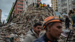 Des sauveteurs recherchent des survivants au milieu des décombres d'un immeuble qui s'est effondré après le séisme dans la ville d'Adana en Turquie le 6 février 2023.