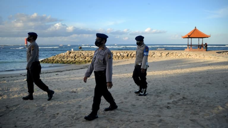 Des policiers patrouillent sur une  plage de Bali pour faire appliquer les mesures de restrictions, le 3 juillet 2021