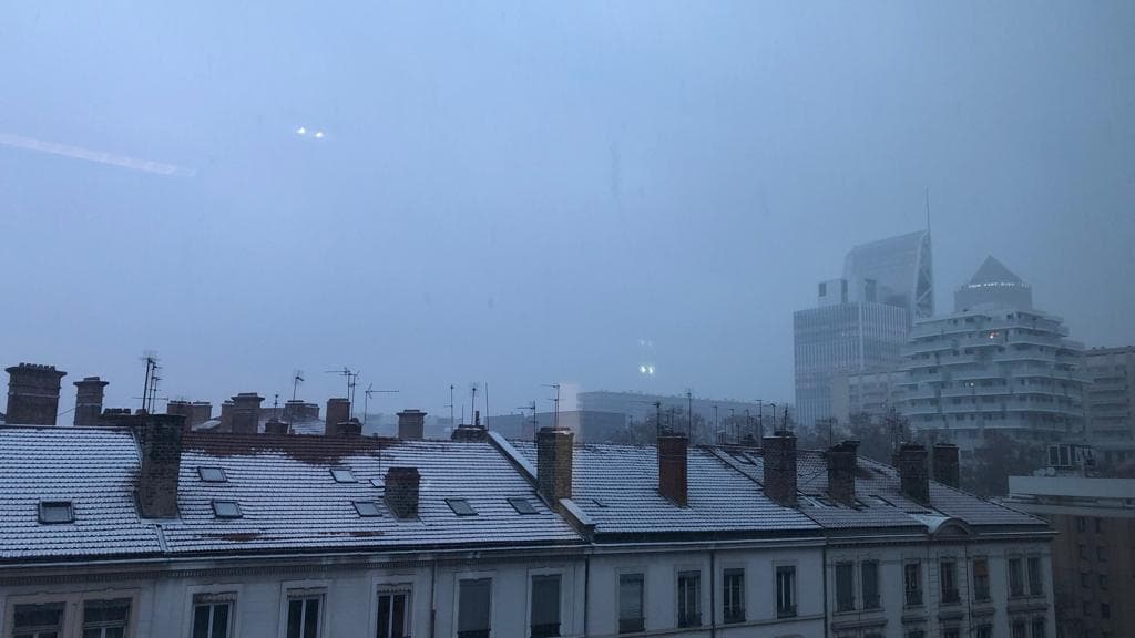 La neige a recouvert les toits d'une fine couche blanche.