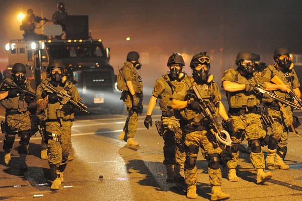 Des officiers de police équipés comme des militaires, le 18 août 2014, à Ferguson, dans le Missouri. Des officiers de police équipés comme des militaires, le 18 août 2014, à Ferguson, dans le Missouri.