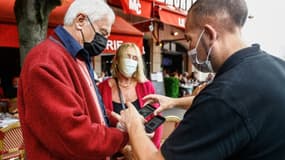 Un serveur d'un café de Deauville scanne le pass sanitaire de clients le 27 juillet 2021