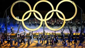 Des anneaux olympiques en bois sont hissés par des participants lors de la cérémonie d'ouverture des Jeux, le 23 juillet 2021 au Stade Olympique à Tokyo