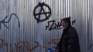 Un homme devant le symbole de l'anarchisme en Grèce en mars 2017 (image d'illustration)