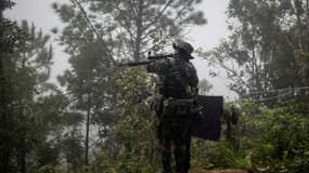 Un rebelle anti-junte pointe son arme pendant un entraînement dans une forêt de l'Etat Karen, en Birmanie, le 16 octobre 2021