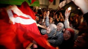 Des partisans de la formation islamiste Ennahda célèbrent leur victoire aux élections constituantes de mardi, devant le siège du parti à Tunis. Ennahda a dit mardi soir avoir gagné plus de 40% des sièges. /Photo prise le 25 octobre 2011/REUTERS/Zohra Bens