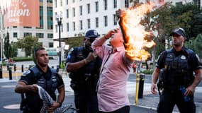 La police aide un homme qui a tenté de s'immoler par le feu, à Washington, alors que les gens manifestent pour marquer le premier anniversaire de la guerre entre le Hamas et Israël