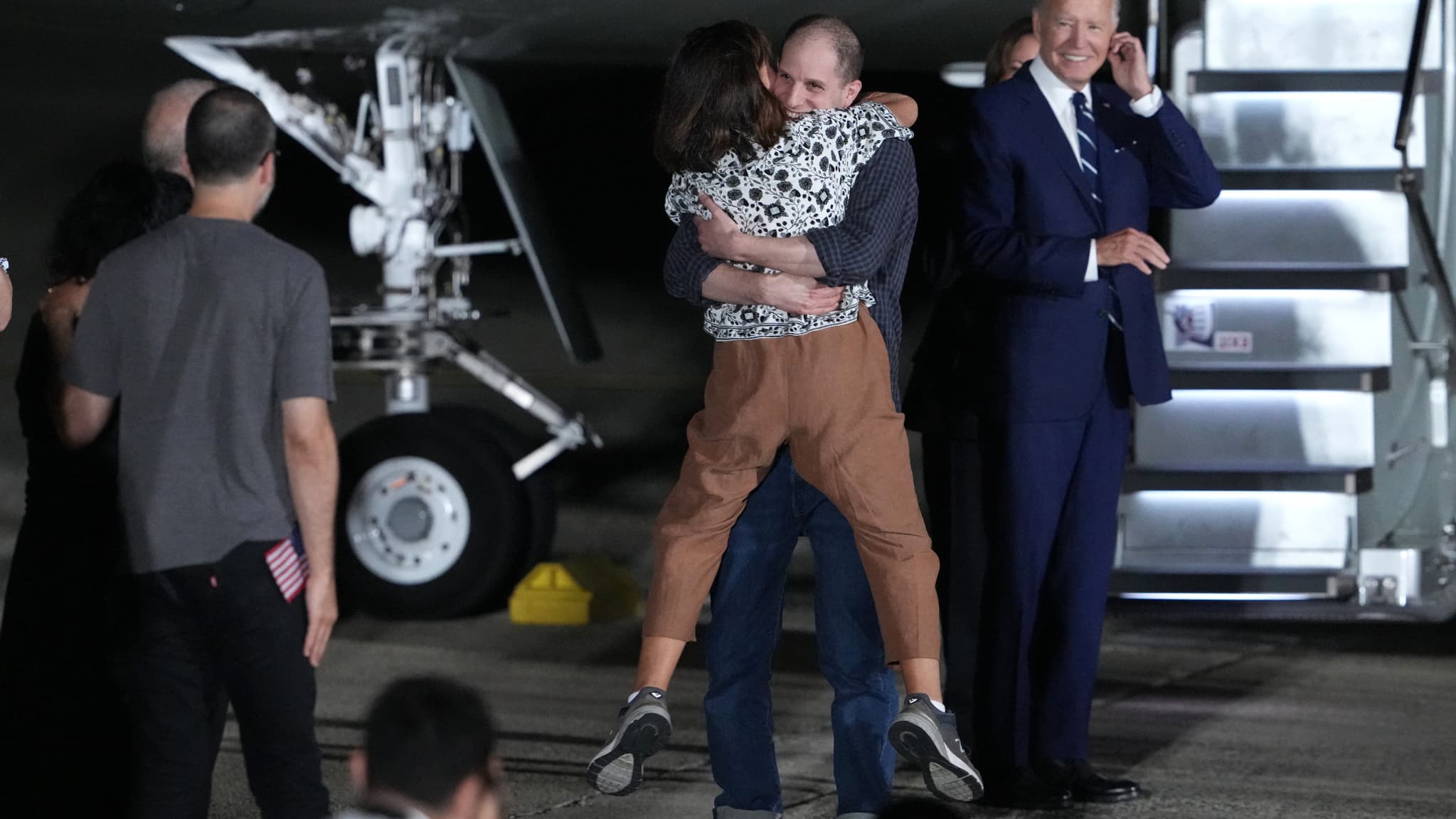Van Gershkovich salue sa mère Ella Milman après son retour aux États-Unis, sous le regard du président américain Joe Biden, le 1er août 2024 à la base conjointe Andrews, dans le Maryland. 