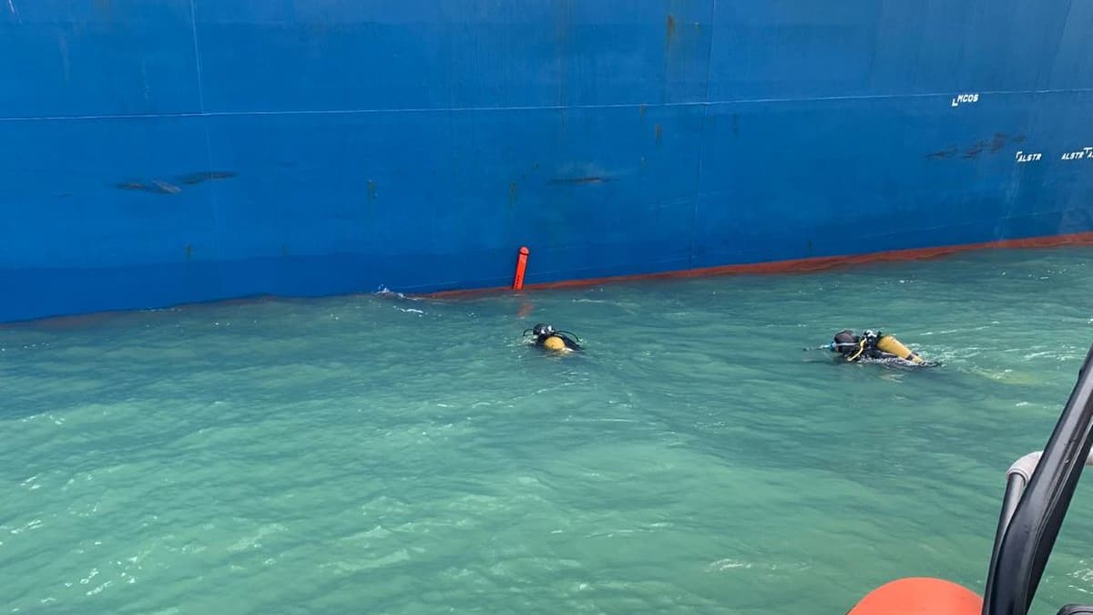 Des plongeurs inspectent la coque du bateau arraisonné
