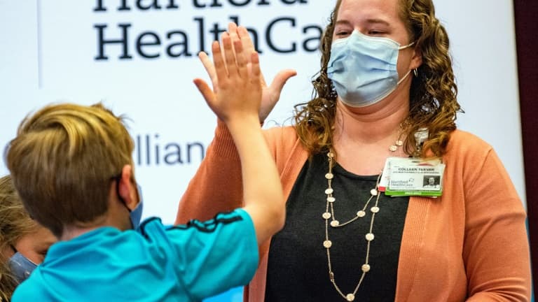 Un enfant de 10 ans tape dans la main de la professionnelle de santé Colleen Teevan après avoir reçu le vaccin de Pfizer contre le Covid-19, le 2 novembre 2021 à Hartford dans le Connecticut