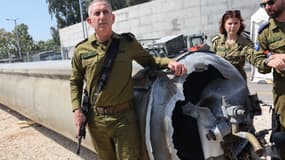 Le porte-parole militaire israélien, le contre-amiral Daniel Hagari pose, le 16 avril 2024, à côté d'un missile balistique iranien tombé en Israël le week-end dernier.