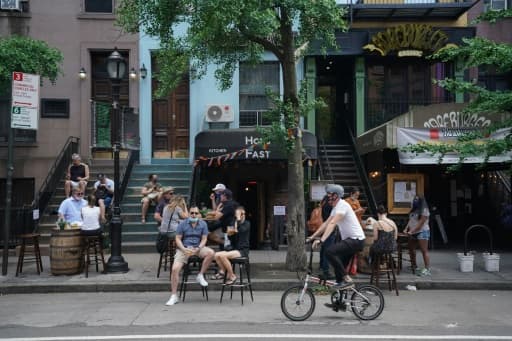 Des habitants en terrasse devant un bar à New York le 7 juin 2020 Des habitants en terrasse devant un bar à New York le 7 juin 2020
