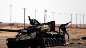 Combattant rebelle près d'un char détruit à l'entrée ouest d'Ajdabiah. Les ministres des Affaires étrangères du "groupe de contact" sur la Libye se réunissent ce mercredi au Qatar au moment où l'enlisement de la situation provoque des tiraillements parmi