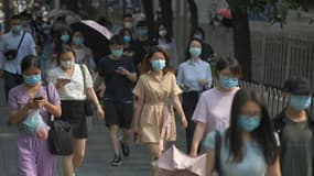 Des Chinois portent des masques de protection contre le coronavirus dans une rue de Pékin, le 28 juin 2020 