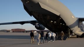 Cette image publiée par le ministère de la Défense montre des agents des douanes et de la protection des frontières des États-Unis guidant des migrants sans papiers pour monter à bord d'un avion.