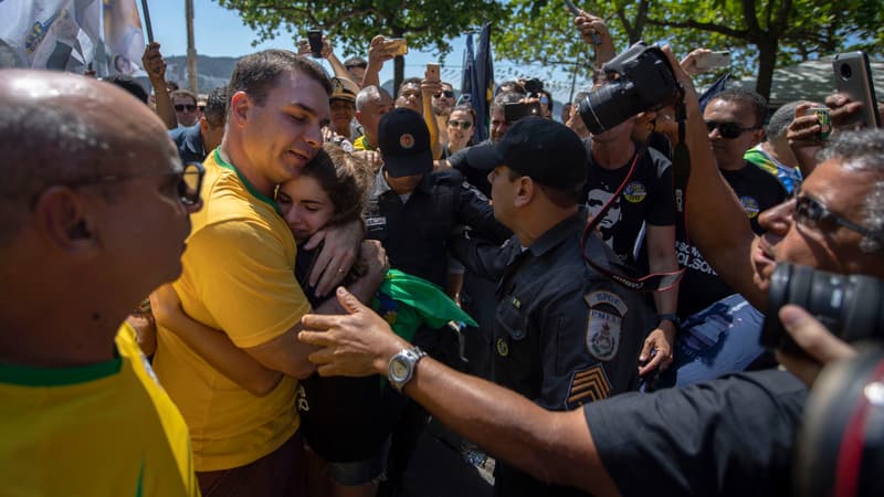Flavio Bolsonaro, le fils du candidat Jair Bolsonaro, enlace une supportrice de son père lors d'un meeting à Copacabana, à Rio, le 9 septembre.