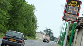Des voitures passent le 2 juin 2011 devant un panneau indicateur de vitesse sur une route nationale près de Vienne (Rhône). 