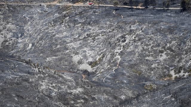 Un camion de pompiers traverse un paysage dévasté par les incendies près de Carnoux-en-Provence dans le sud-est de la France, le 22 août 2017