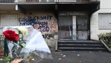 Cette photographie prise le 22 décembre 2022 montre l'entrée d'un immeuble incendié alors que des fleurs sont déposées lors d'une "Marche Blanche" en mémoire des victimes de l'incendie d'un immeuble, à Vaulx en Velin, dans la banlieue nord de Lyon, dans le sud-est de la France, après la mort de dix habitants dans l'incendie qui s'est déclaré le 16 décembre dans un immeuble délabré. 