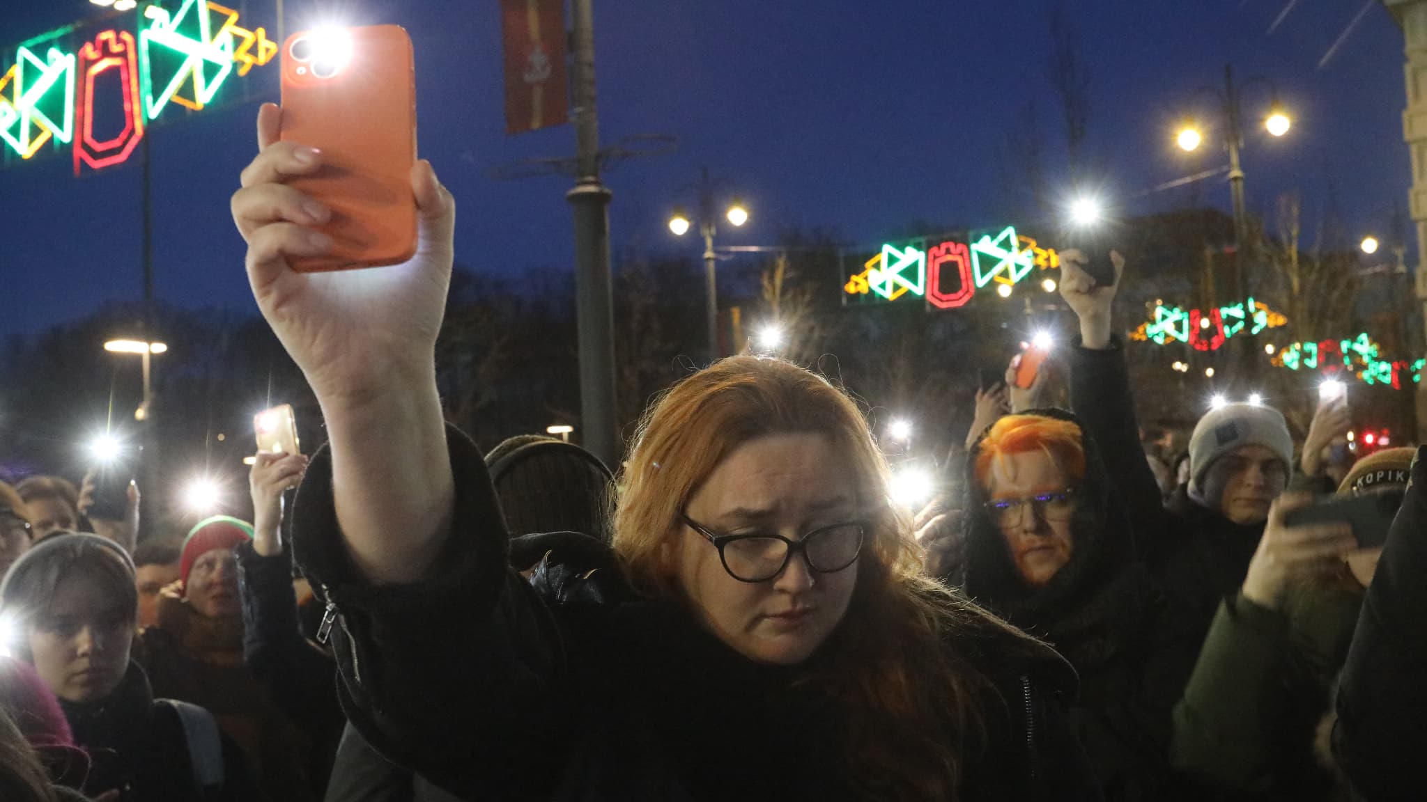Des personnes manifestent et rendent hommage à l'opposant russe Alexei Navalny, au monument des victimes des répressions politiques à Vilnius, en Lituanie, le 16 février 2024.