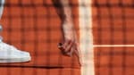 Un arbitre de chaise pointe du doigt une marque laissée par une balle sur la terre battue de Roland-Garros.