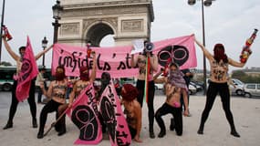 Les Femen manifestent seins nus et kalachnikovs en plastique à la main sur les Champs-Elysées, mercredi 24 septembre 2014.