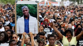 Des manifestants lèvent un portrait d'Adama Traoré en son hommage ce samedi à Beaumont-sur-Oise.