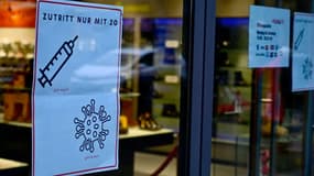 Une affiche à l'entrée d'un magasin indique que seules les personnes vaccinées ou guéries du Covid-19 sont autorisées à entrer, le 13 décembre 2021 à Berlin.